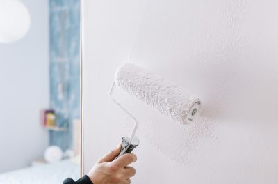 painting a wall in white with a roller hand painting a wall in white with a roller, home decoration and renovation concept, horizontal photo with copy space for text