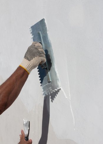 Builder using plastering tool for finishing wall. Builder using plastering tool for finishing wall